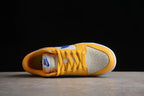 Top-down view of the sneaker showing yellow-gold laces, a perforated light-colored toe box, and padded collar.