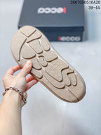 Close-up of the textured patterned outsole on a cream and tan sneaker.