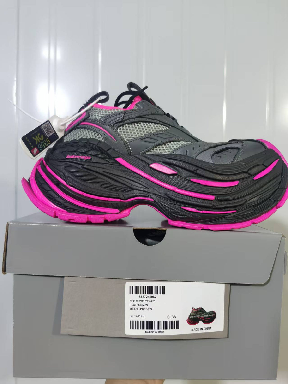 Side view of the grey and pink sneaker above its box; the label shows style 0125, colour GREY/PINK, and a photographed size of 38.