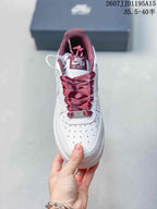 Top view of a white sneaker with a perforated toe box, burgundy laces, and Air Force 1 tongue branding.