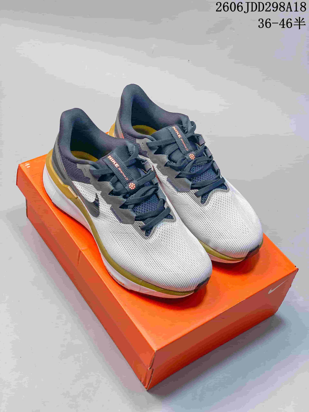 Pair of light gray Nike running shoes with dark laces and contrasting heel details.