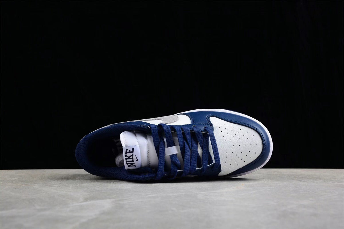 Top-down view showing the white perforated toe box, navy laces, and padded tongue.