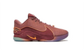 Side view of a burgundy-toned Nike LeBron 22 low-top sneaker with gold-orange accents and a multicolor outsole