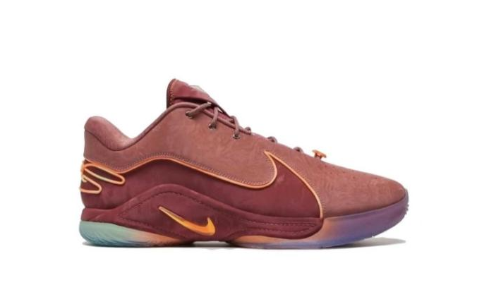 Side view of a burgundy-toned Nike LeBron 22 low-top sneaker with gold-orange accents and a multicolor outsole