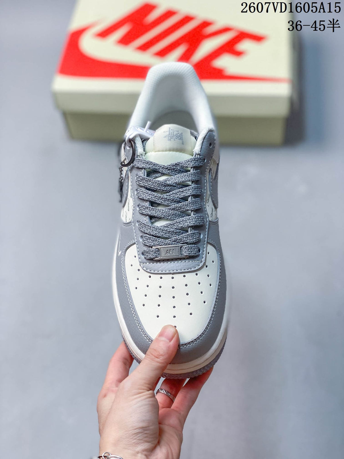 Top view showing the perforated off-white toe box, grey laces, lace tag, and padded tongue.