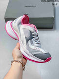 Gray and white mesh sneaker with pink accents and a chunky sole