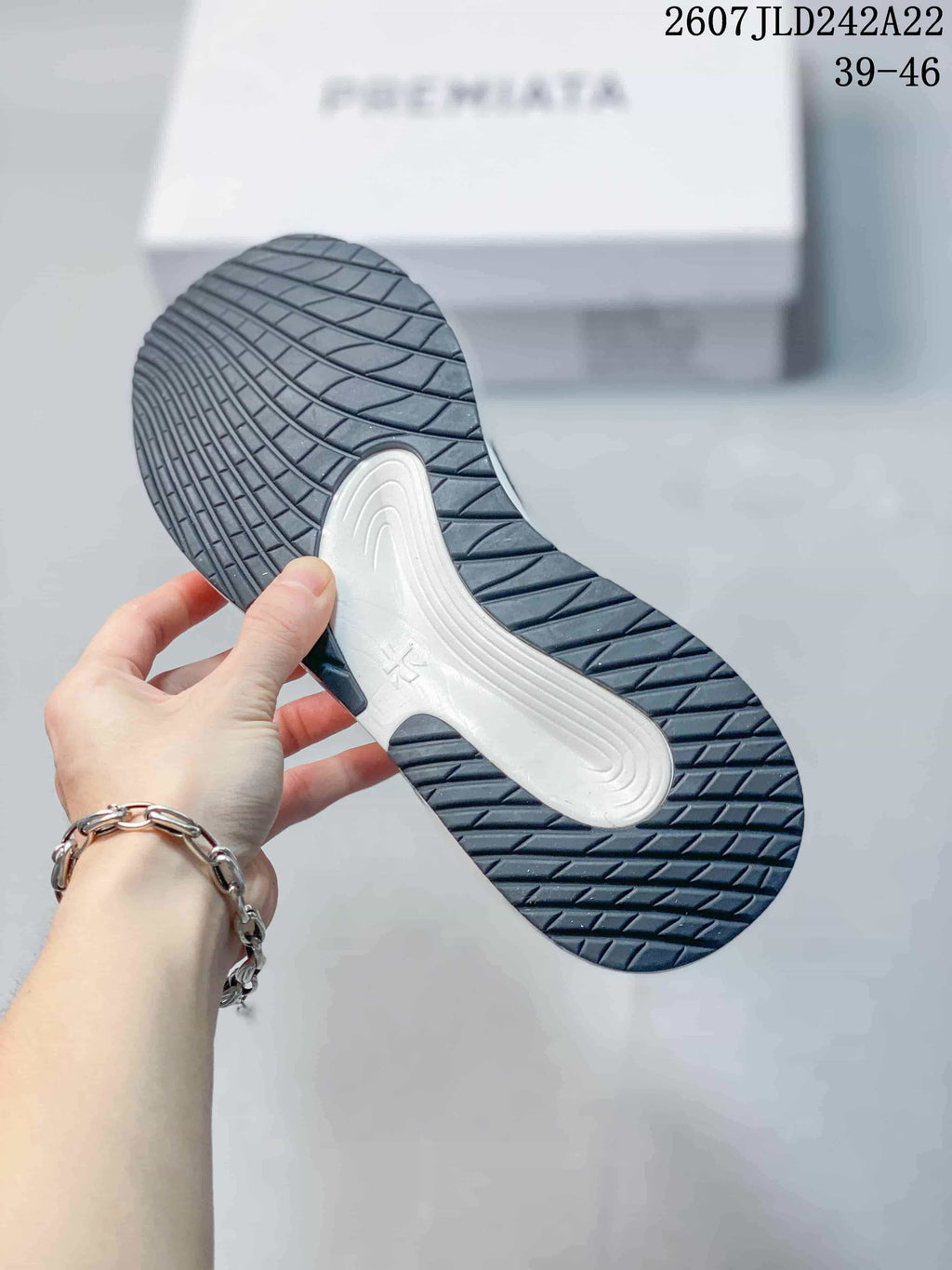 Close view of the dark rubber outsole with textured tread and a contrasting white midfoot section.