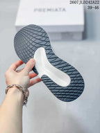 Close view of the dark rubber outsole with textured tread and a contrasting white midfoot section.