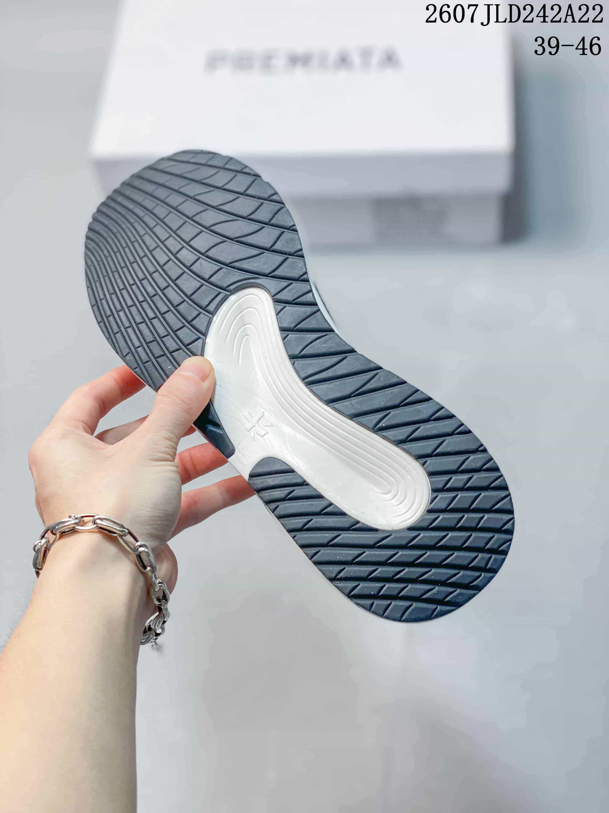 Close view of the dark rubber outsole with textured tread and a contrasting white midfoot section.