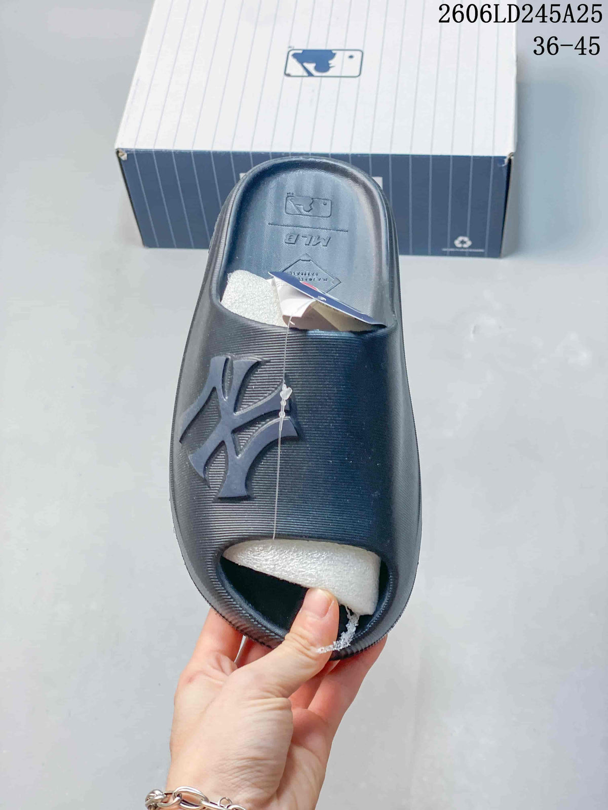 Top view of a single black MLB slide sandal with a wide textured strap and raised logo detail.