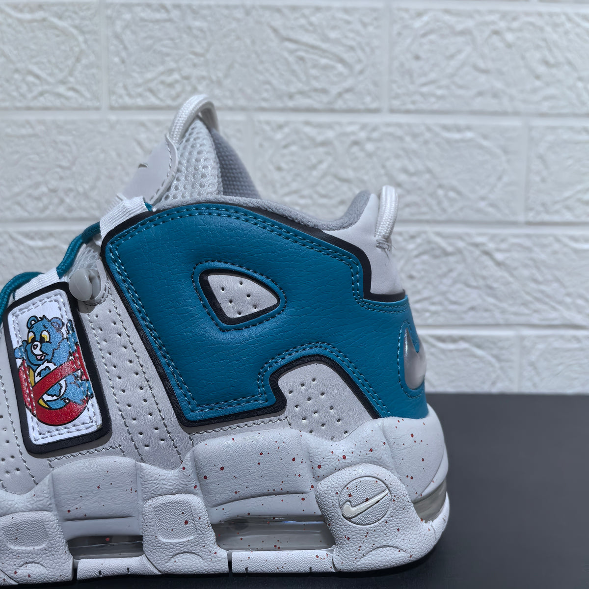 Close-up of the blue heel panel, cartoon bear graphic and speckled white sole
