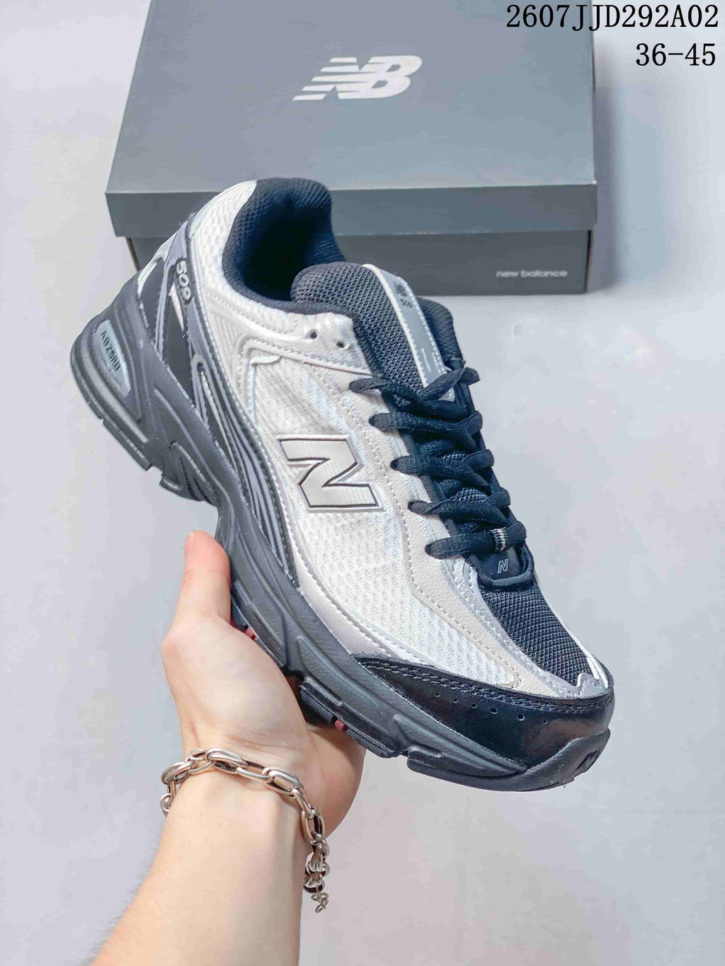 Angled side view of the white and gray New Balance 509 sneaker with navy overlays and a dark sole.
