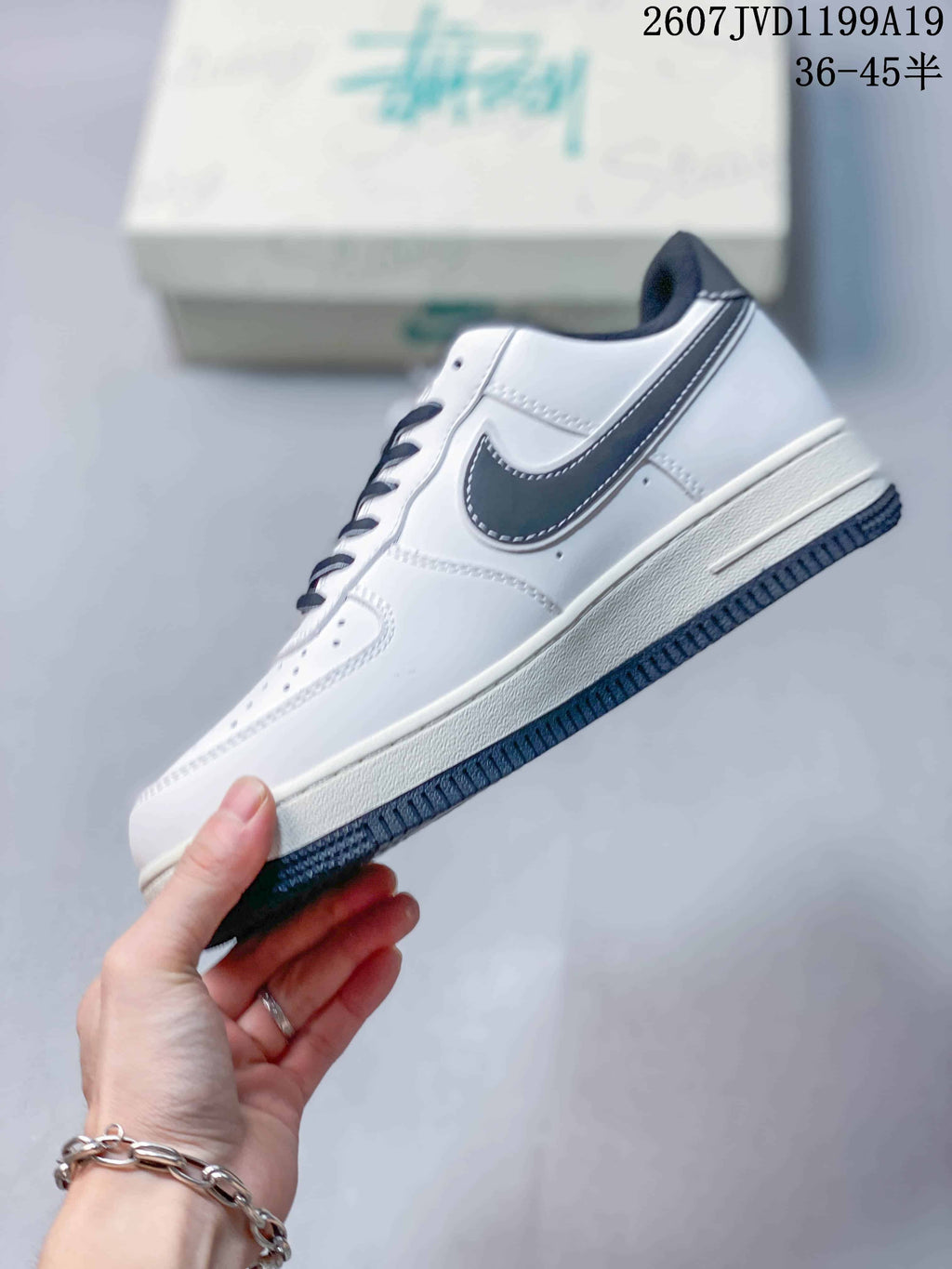 Side profile of the white low-top sneaker showing the dark Swoosh, stitched panels, white midsole, and dark outsole.