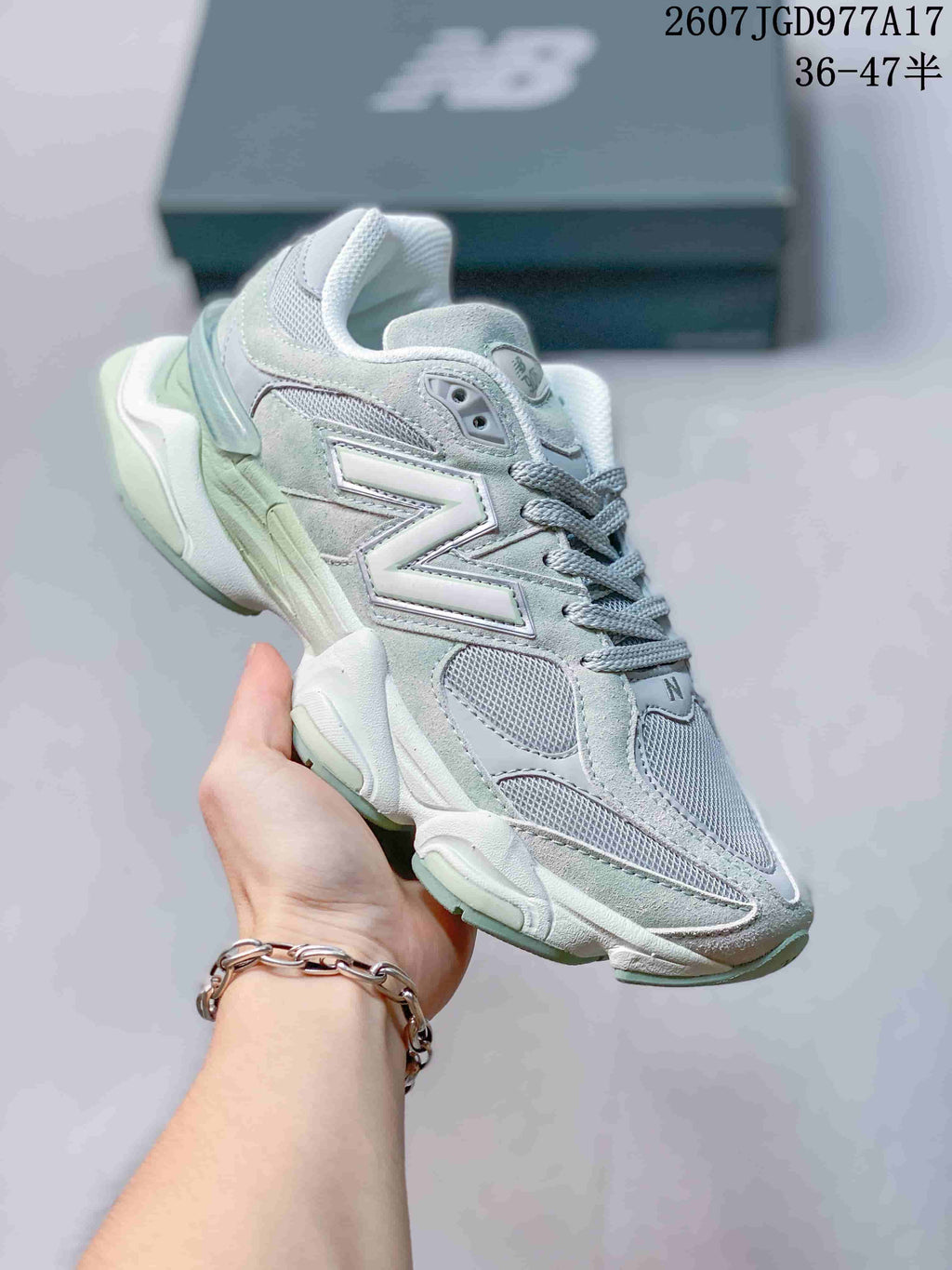 Angled side view of the New Balance 9060 sneaker showing the layered upper, large side logo and mint green outsole accent.