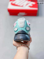 Rear view of the mint and white Nike V5 RNR sneaker showing the padded collar, heel structure and dark outsole.