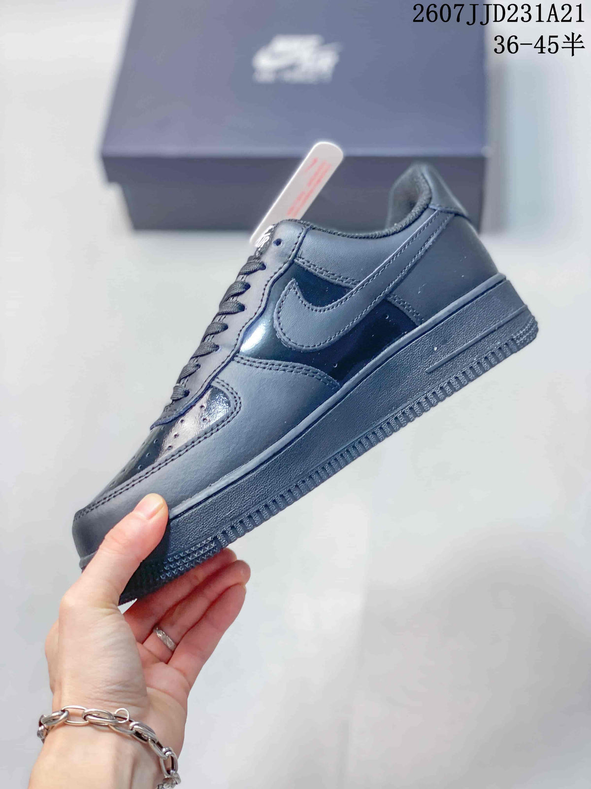 Side view of a black low-top sneaker showing the Swoosh, layered panels and raised sole.
