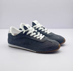 Three-quarter front view of the carbon gray Alo sneakers with white laces and contrasting collars.