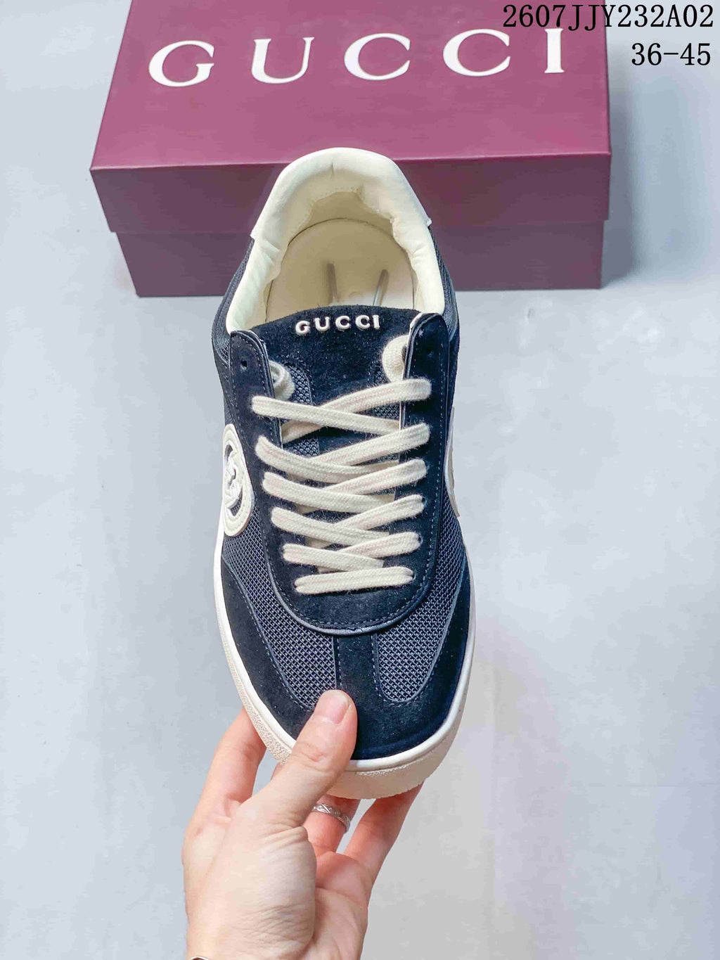 Front view of the navy sneakers with white laces
