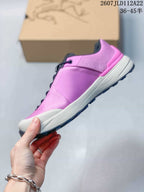 Side profile of the pink and navy low hiking shoe showing the layered upper, white midsole and lugged outsole.