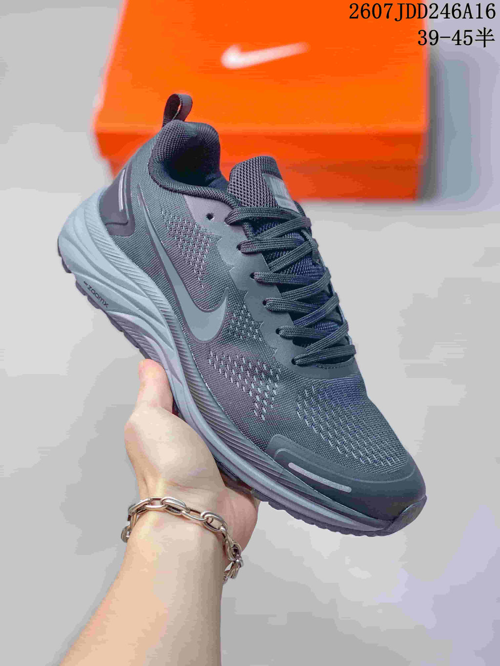Angled side view of the dark Nike running shoe showing the swoosh, mesh-style panels, layered sole, and heel details.