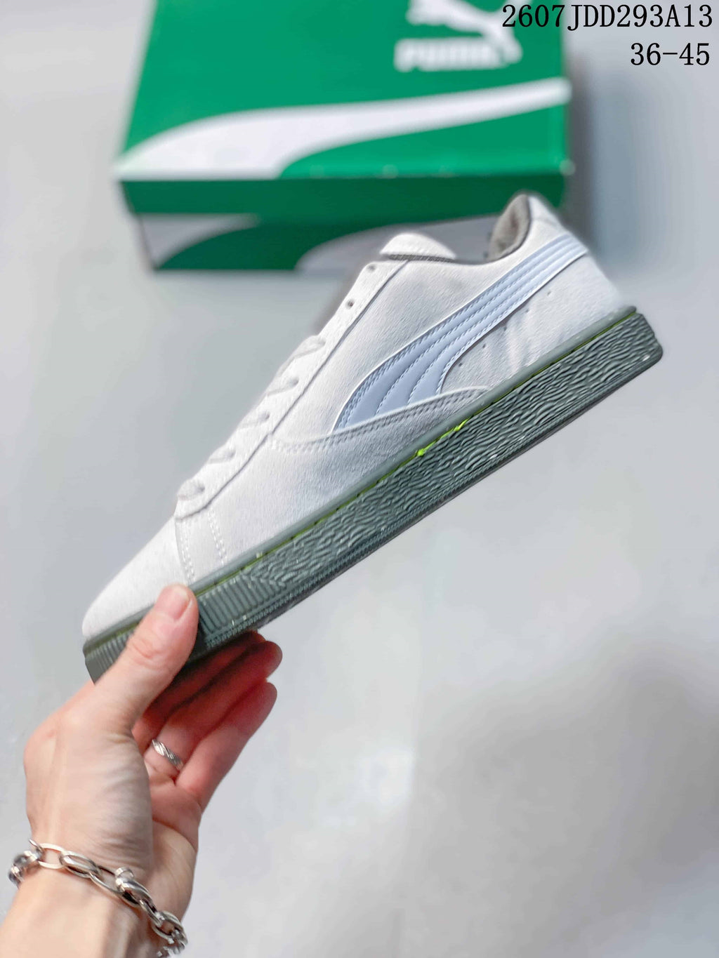 Side view of the white and gray low-top sneaker showing the PUMA formstrip and textured outsole.