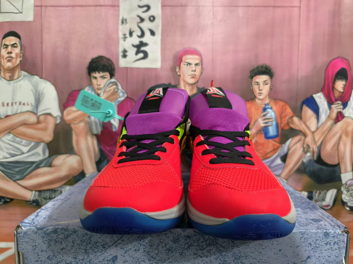 Front view of red basketball shoes with purple tongues, black laces, and blue outsoles.