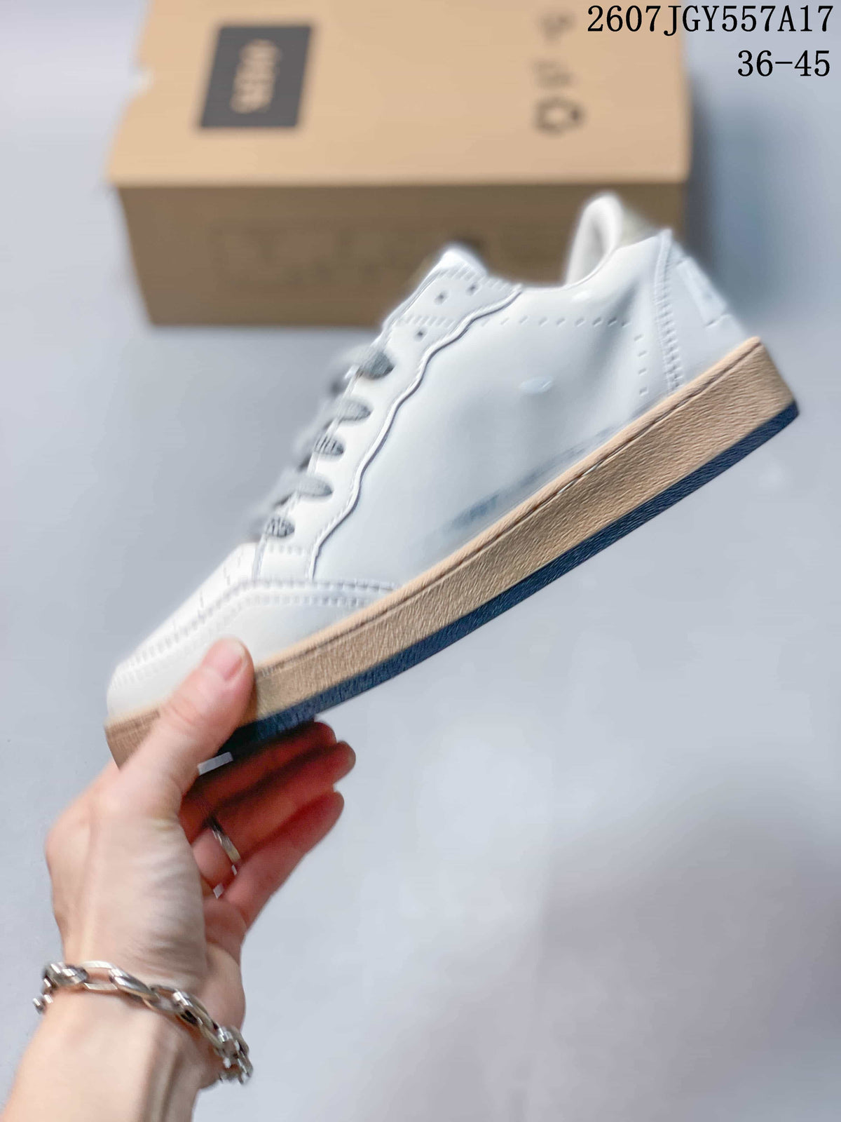 Side profile of a white low-top sneaker with a gum-colored midsole and dark outsole.