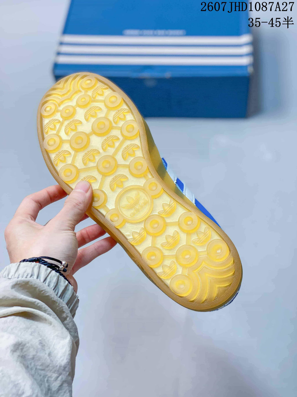 Underside view showing the gum-colored outsole with circular and trefoil-patterned tread.