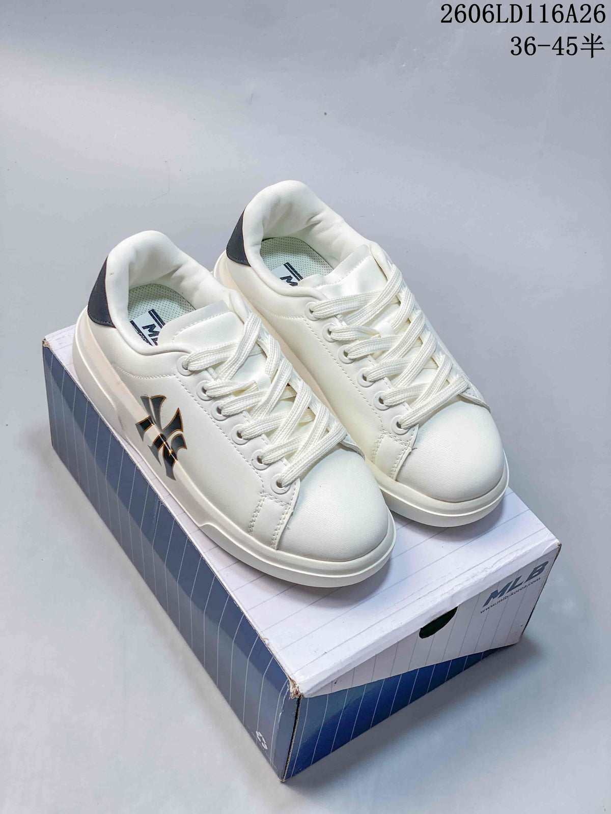 Pair of white low-top sneakers with dark monograms and contrasting heel details