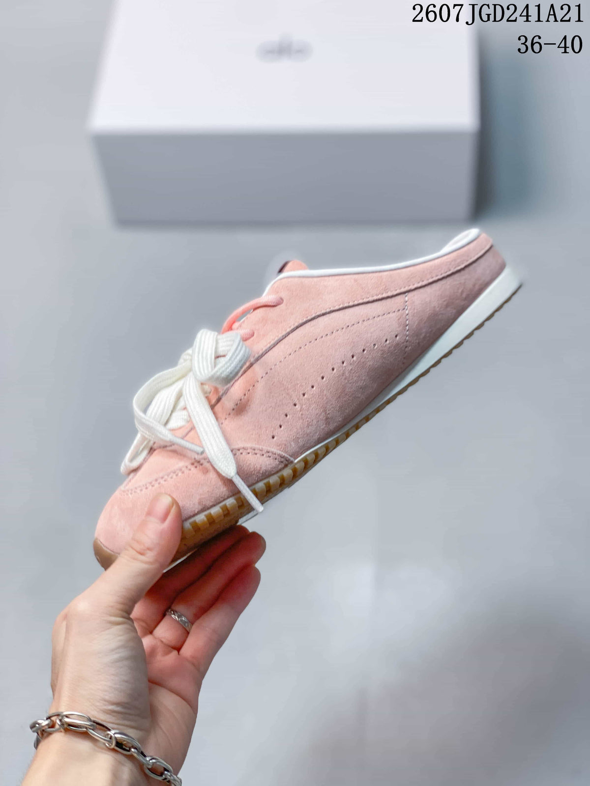 Side view of the pink low-profile sneaker with perforated detailing and gum outsole.