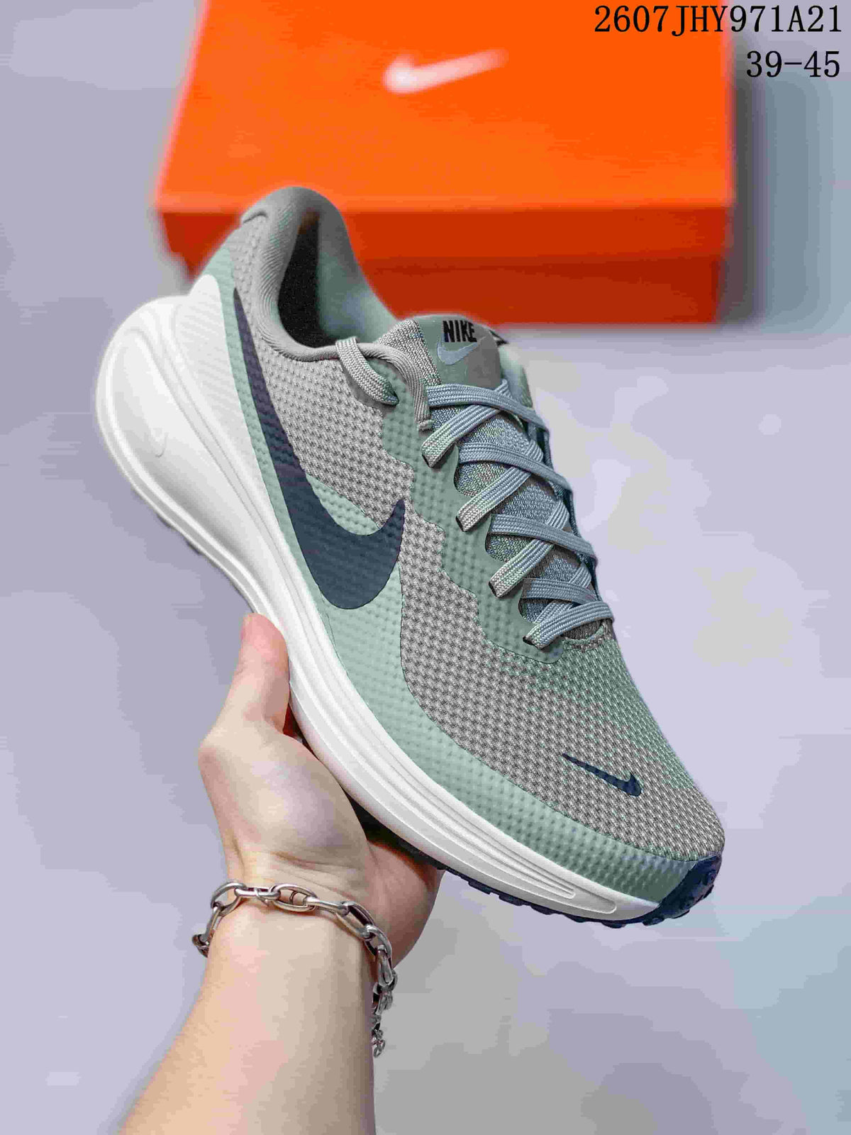 Angled side view showing the gray-green upper, navy Swoosh, white midsole, and dark outsole.