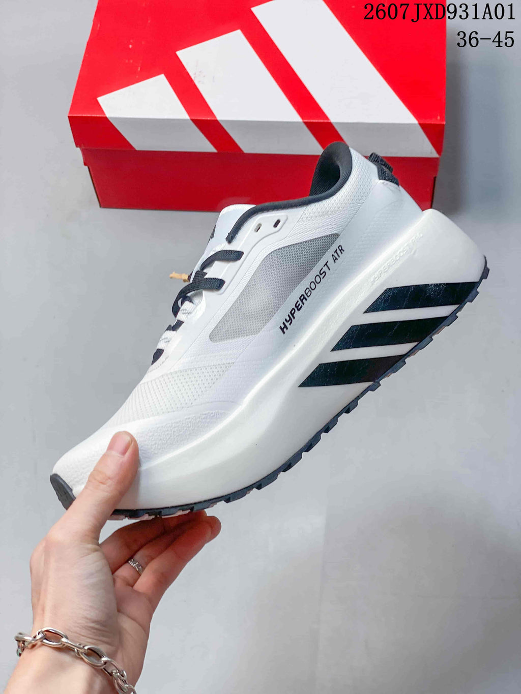 Side view of the white sneaker with black stripes and Hyperboost ATR marking.