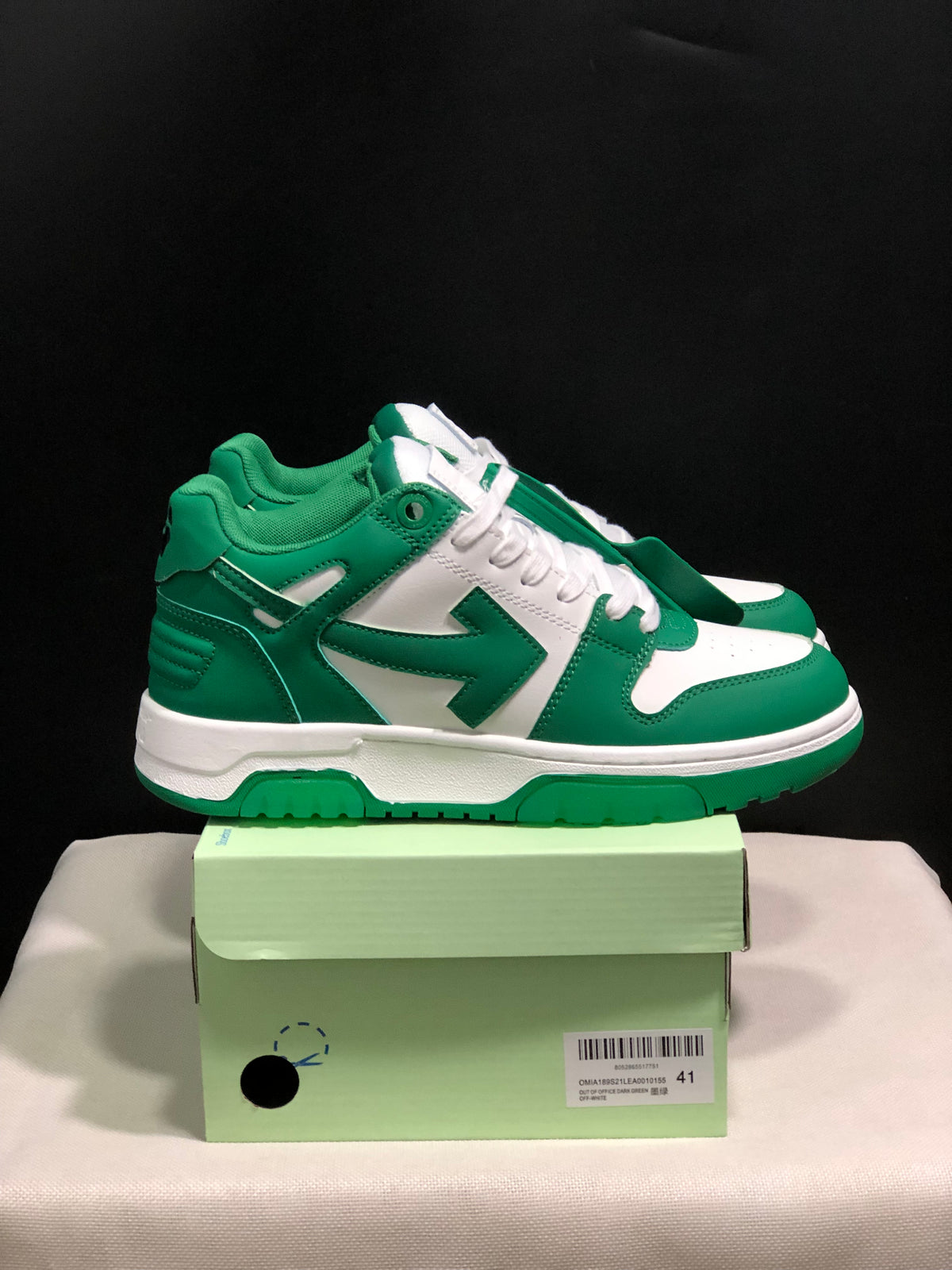 Side view of green and white low-top sneakers showing contrast panels, padded collar and layered sole.