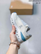 Side view highlighting the textured upper, lace panels, blue heel accent, and segmented midsole.