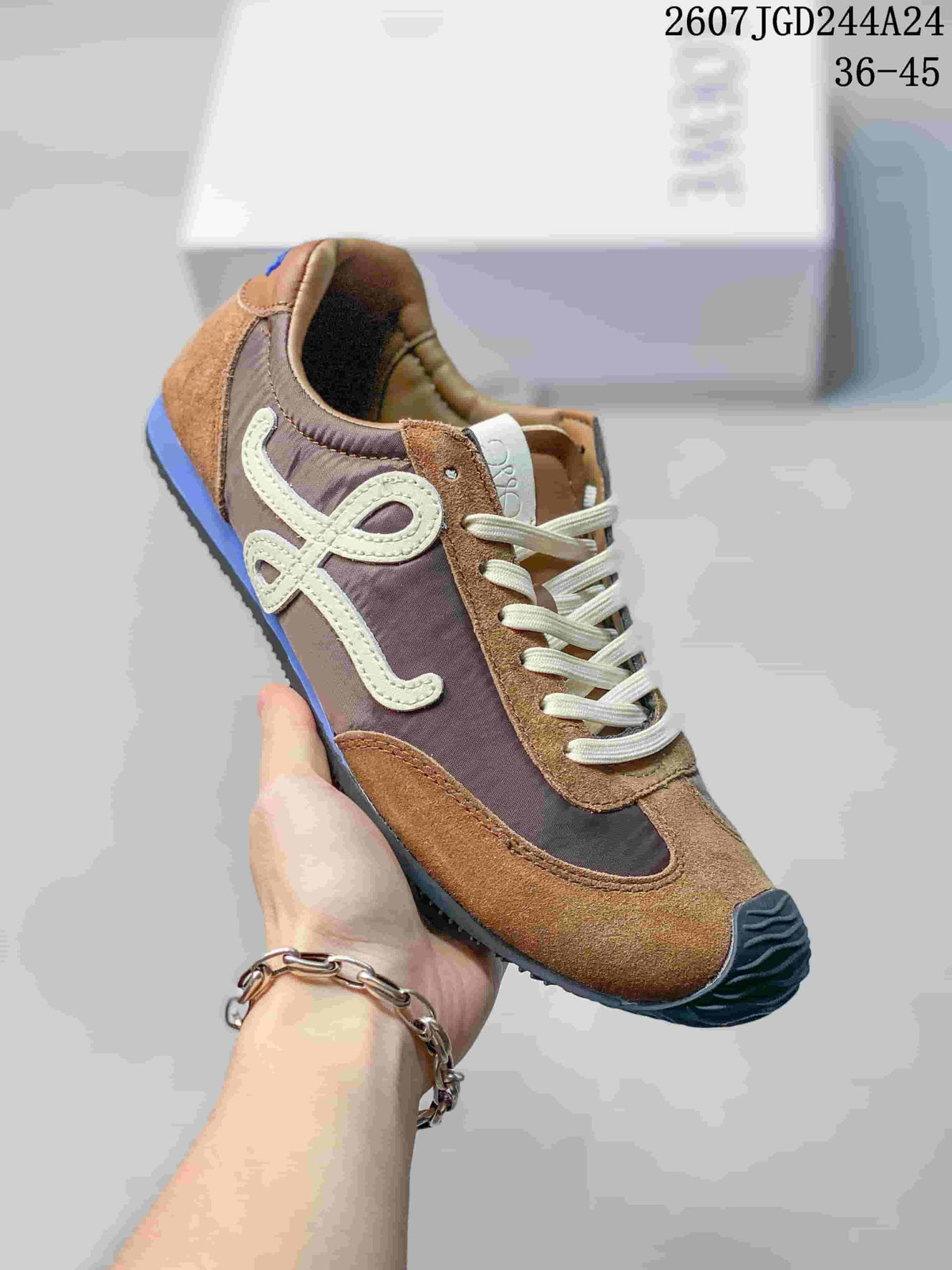 Angled side view showing the brown and gray sneaker upper, cream laces, side logo detail, and dark toe bumper.