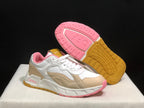 Three-quarter view of one sneaker beside its outsole, showing the pink and gum-colored tread pattern.