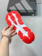 Close view of the sneaker outsole showing segmented red rubber sections and white channels.