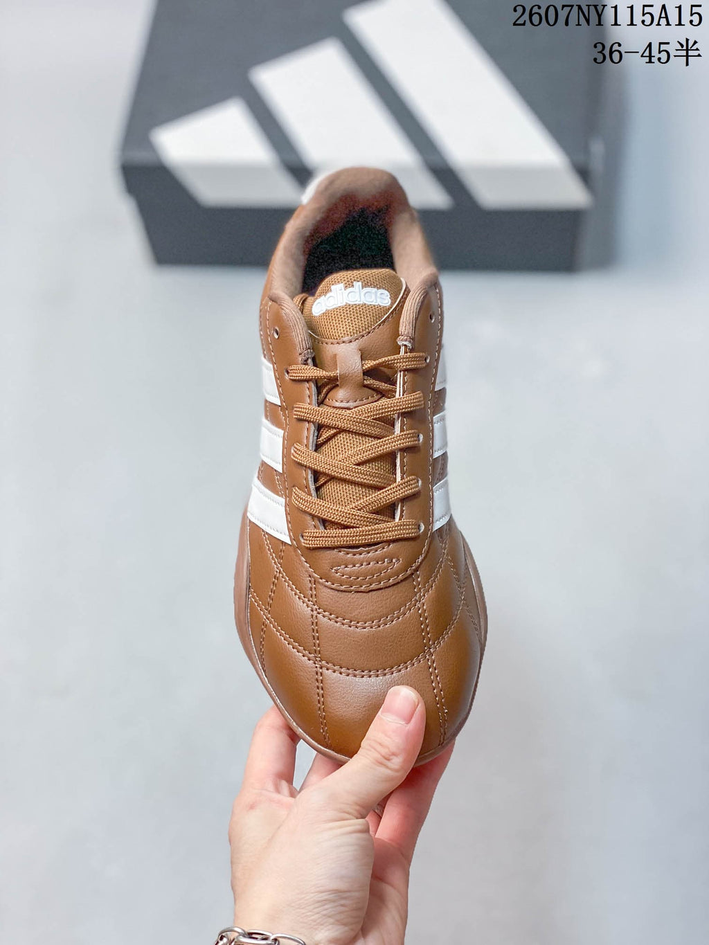 Top view showing the brown laces, padded tongue, stitched toe panels, and white side stripes.