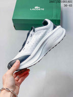 Side view of the white sneaker with navy accents and a chunky white midsole