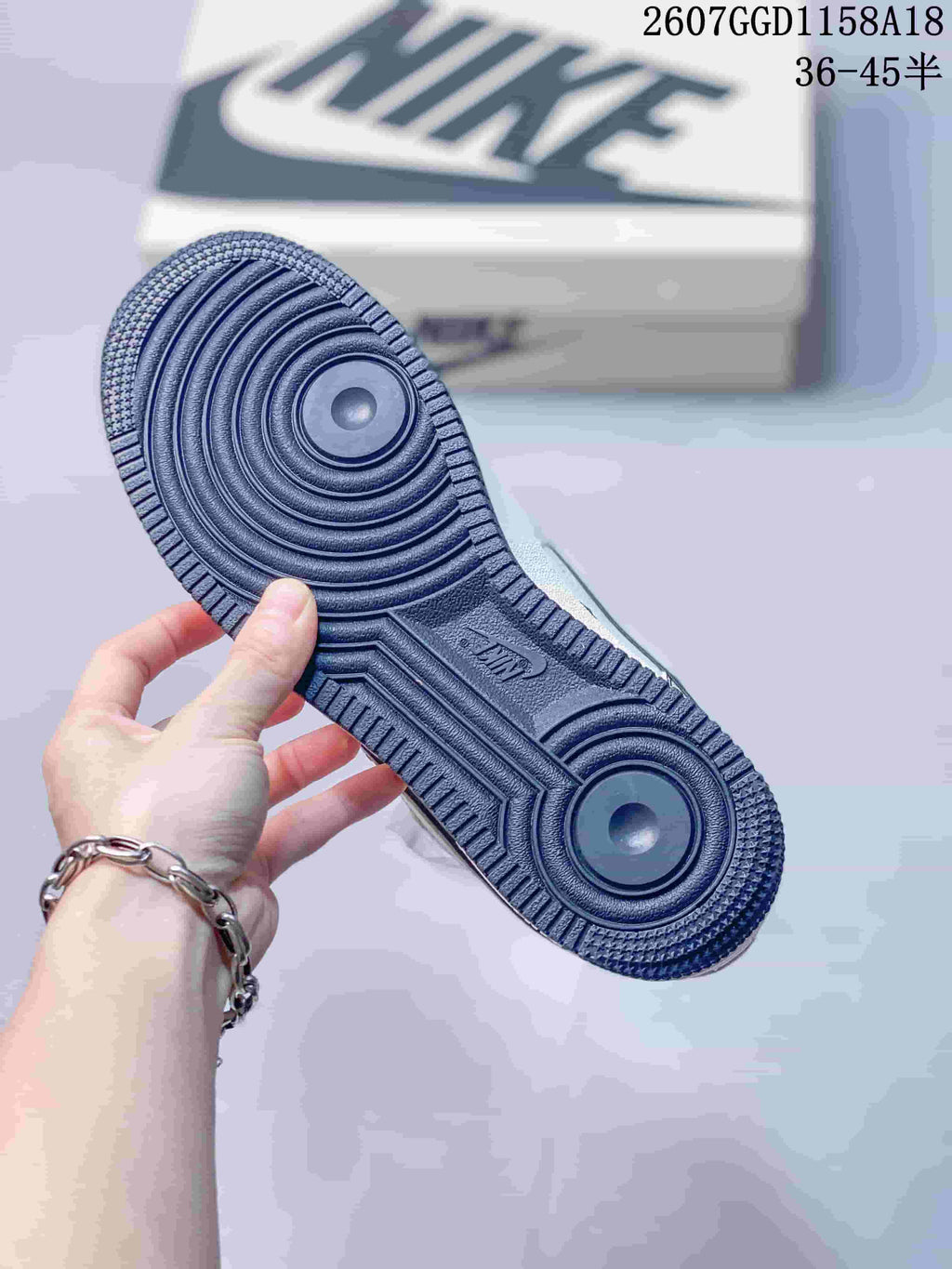 Close-up of the navy textured rubber outsole showing concentric circular traction patterns.