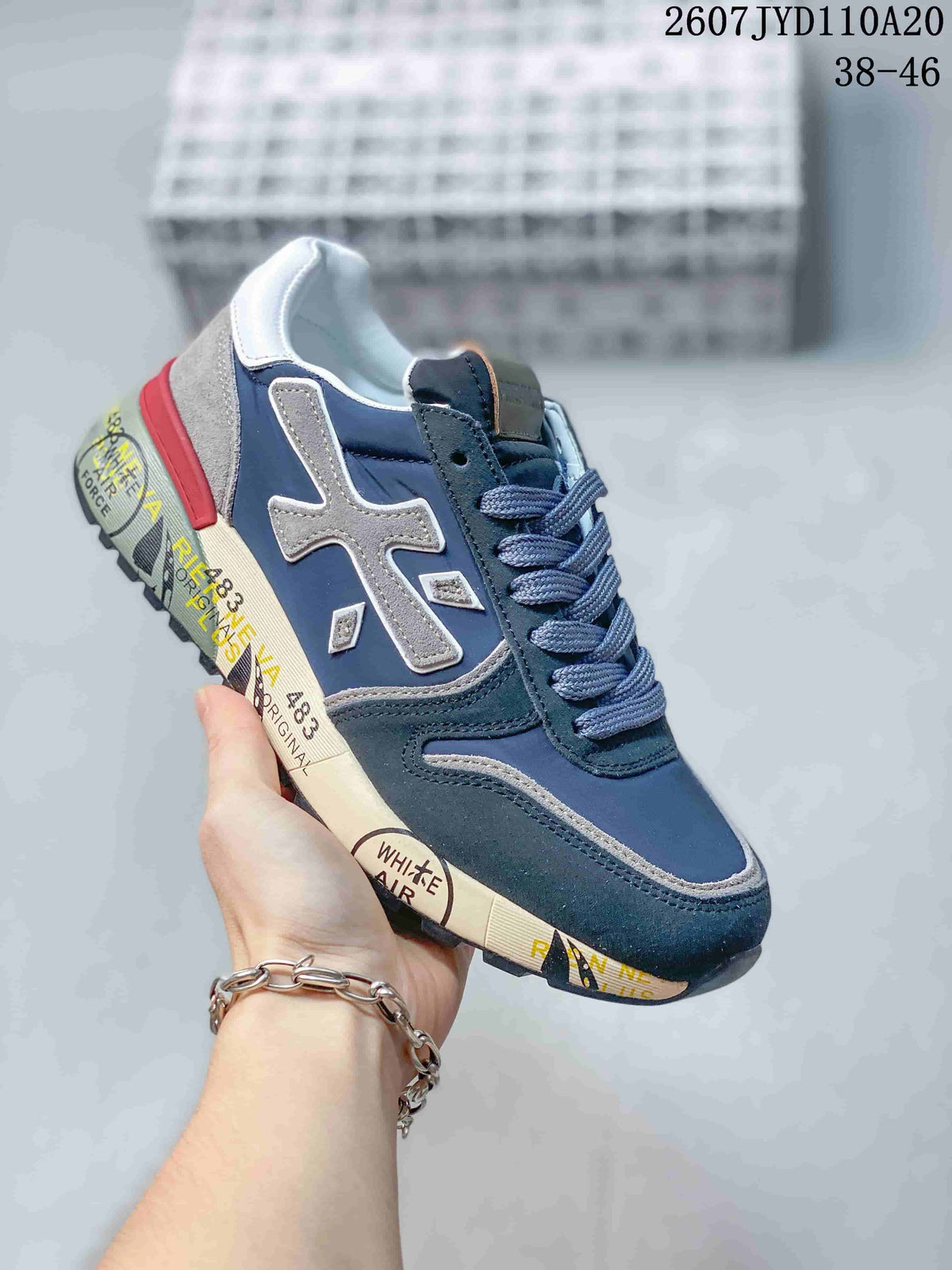 Navy Premiata sneaker with gray side overlays and a red heel accent.