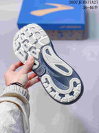 Outsole view showing the textured tread pattern and navy central section of a Brooks running shoe.