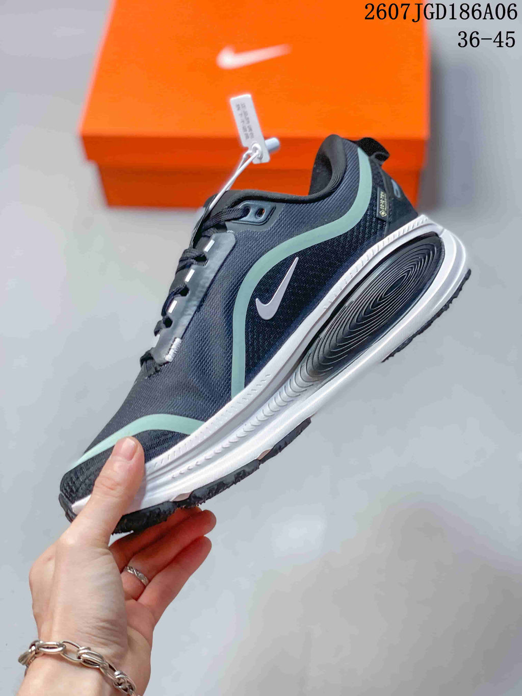 Side profile showing the dark textile-looking upper, mint overlays, white swoosh, sculpted midsole, and black outsole.