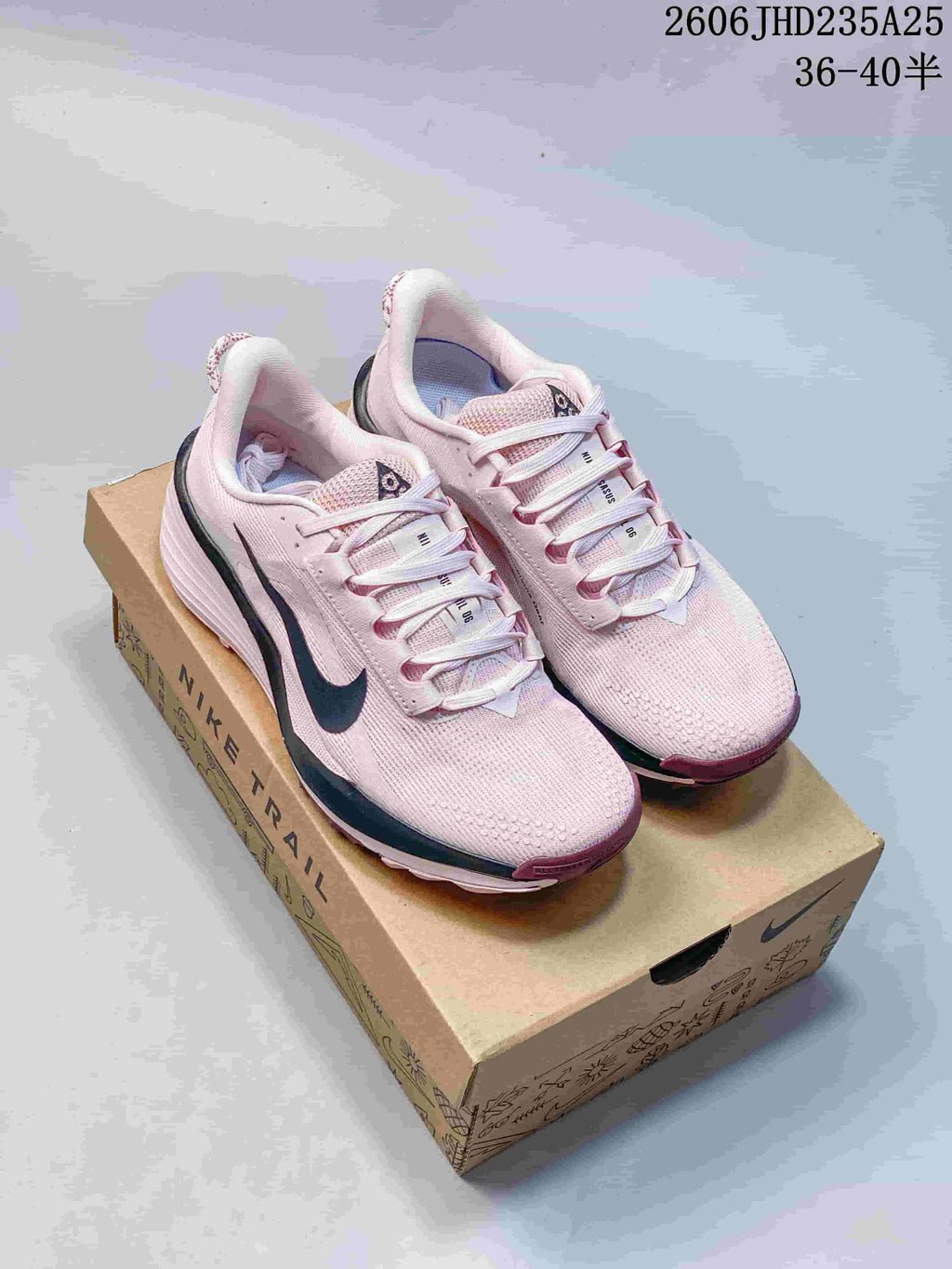 Pair of pale pink Nike trail running shoes displayed on a box