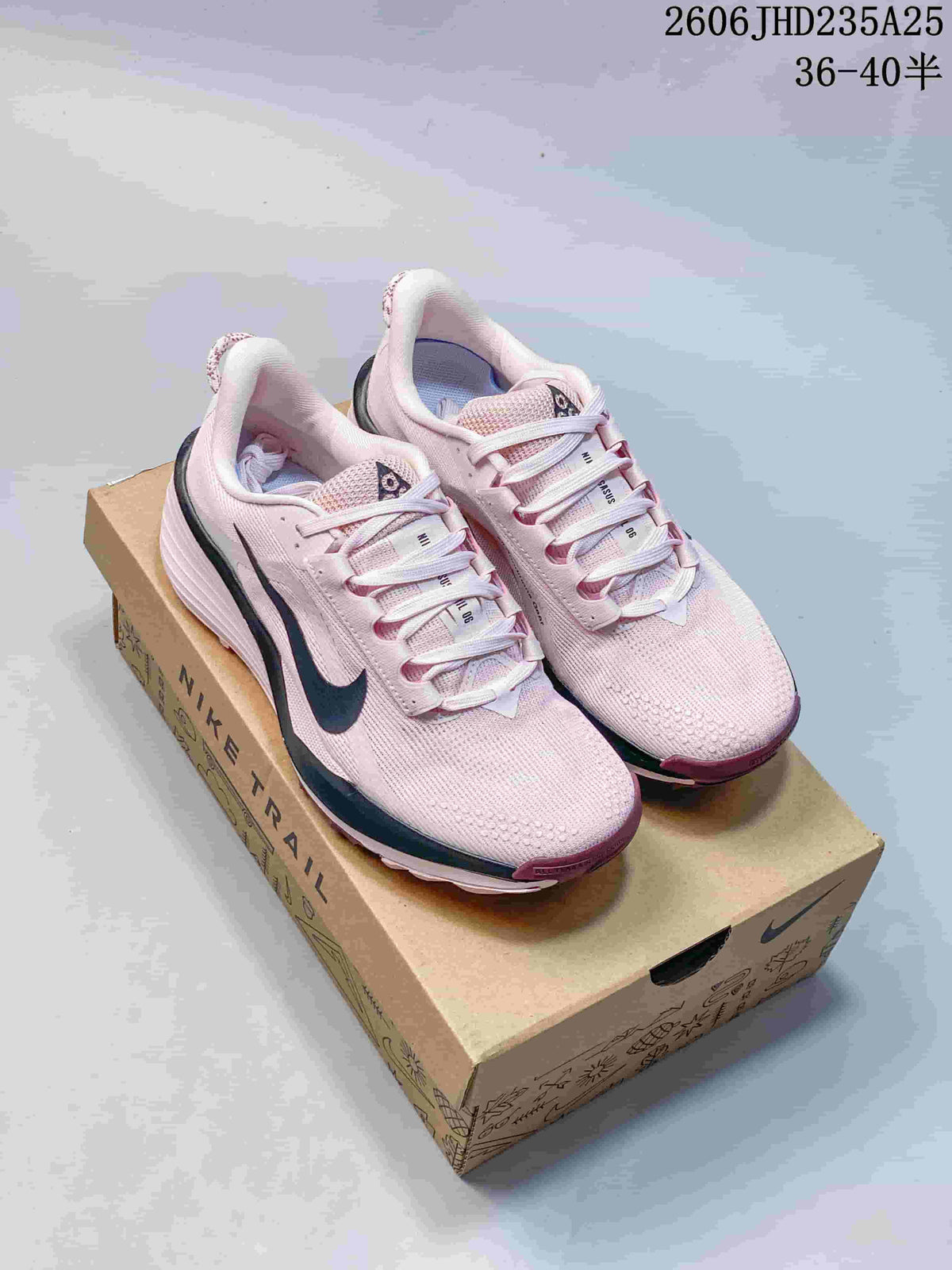Pair of pale pink Nike trail running shoes displayed on a box