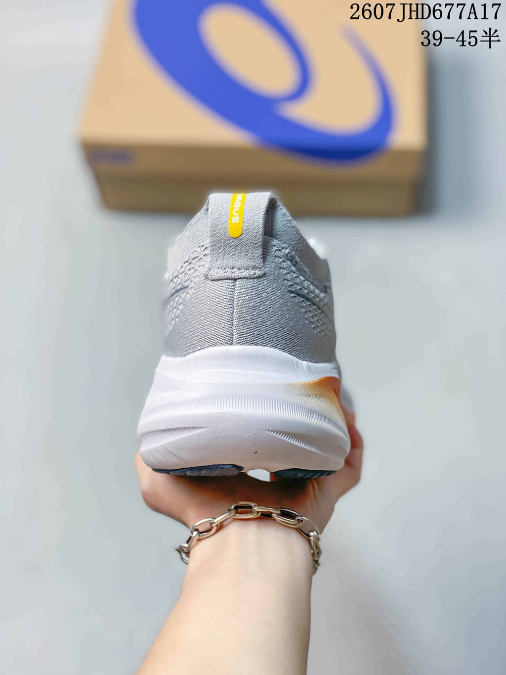 Rear view of the gray running sneaker showing the padded heel collar, heel pull tab, and thick white midsole.