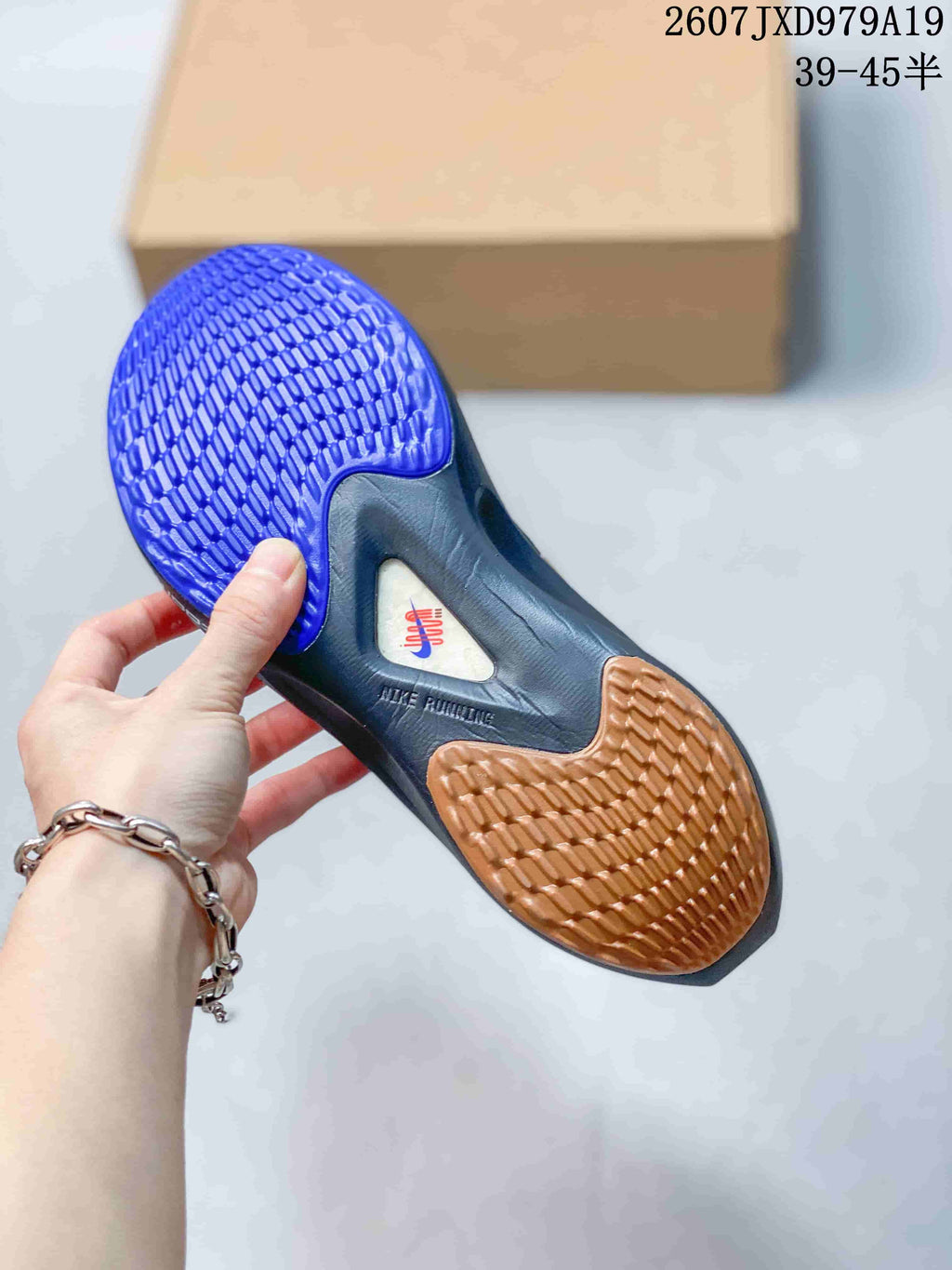 Bottom view of the shoe showing blue and gum-colored patterned outsole sections and visible Nike branding.