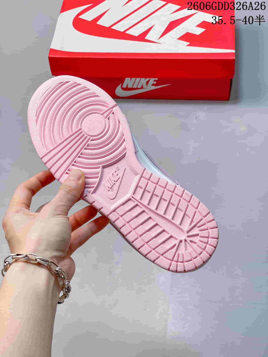 Pink outsole with circular tread and molded branding