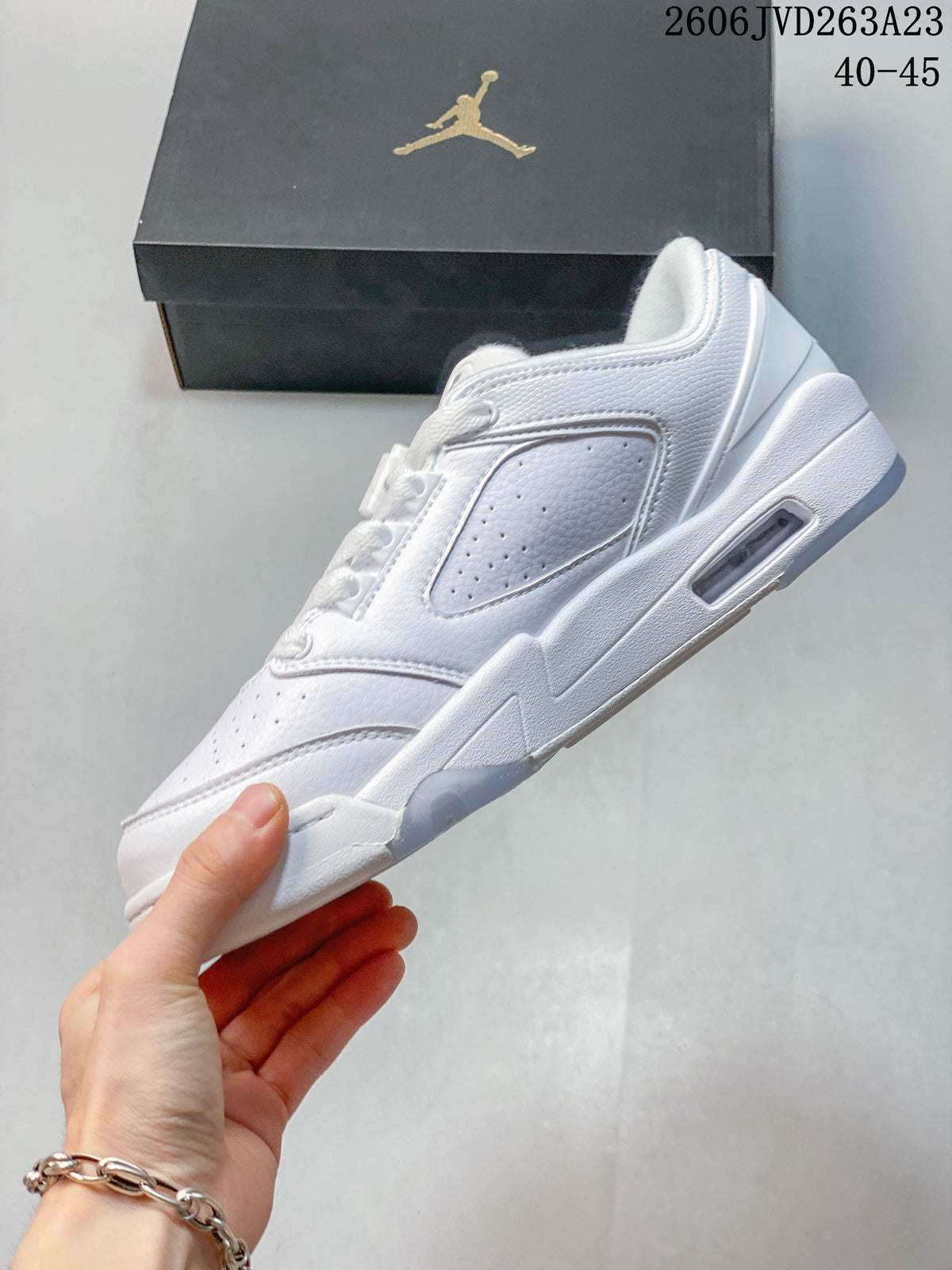 Side profile of a white Jordan Sixty Plus Low sneaker with perforated panels and sculpted sole