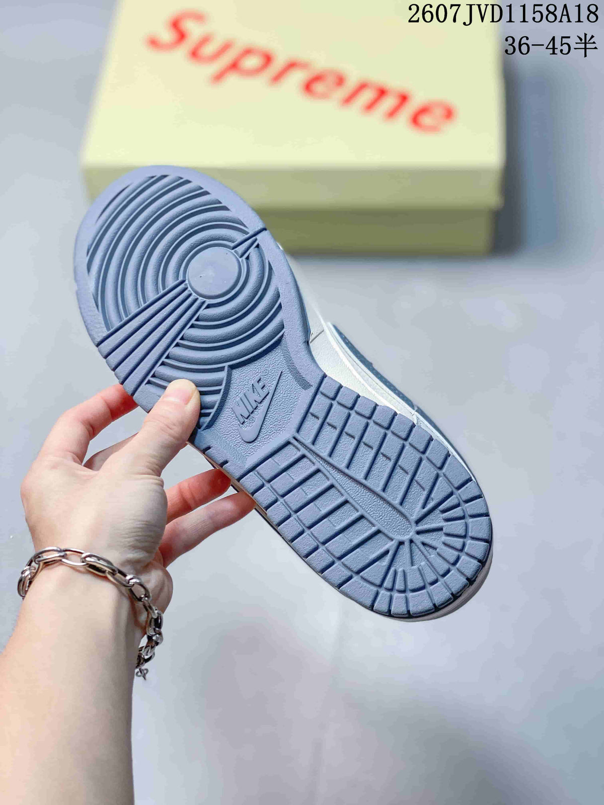 Close view of the gray rubber outsole showing circular and grid traction patterns with Nike branding.